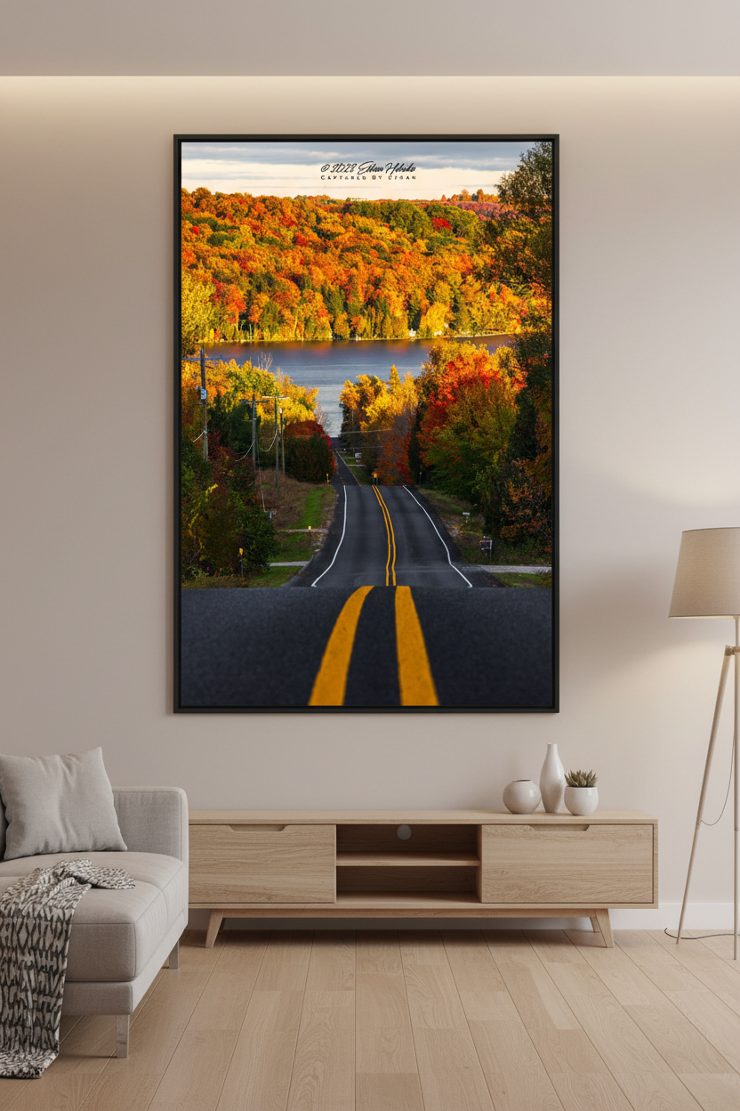 Large fine art portrait print of peak fall color road leading to a lake in Leelanau County Michigan displayed in modern living room
