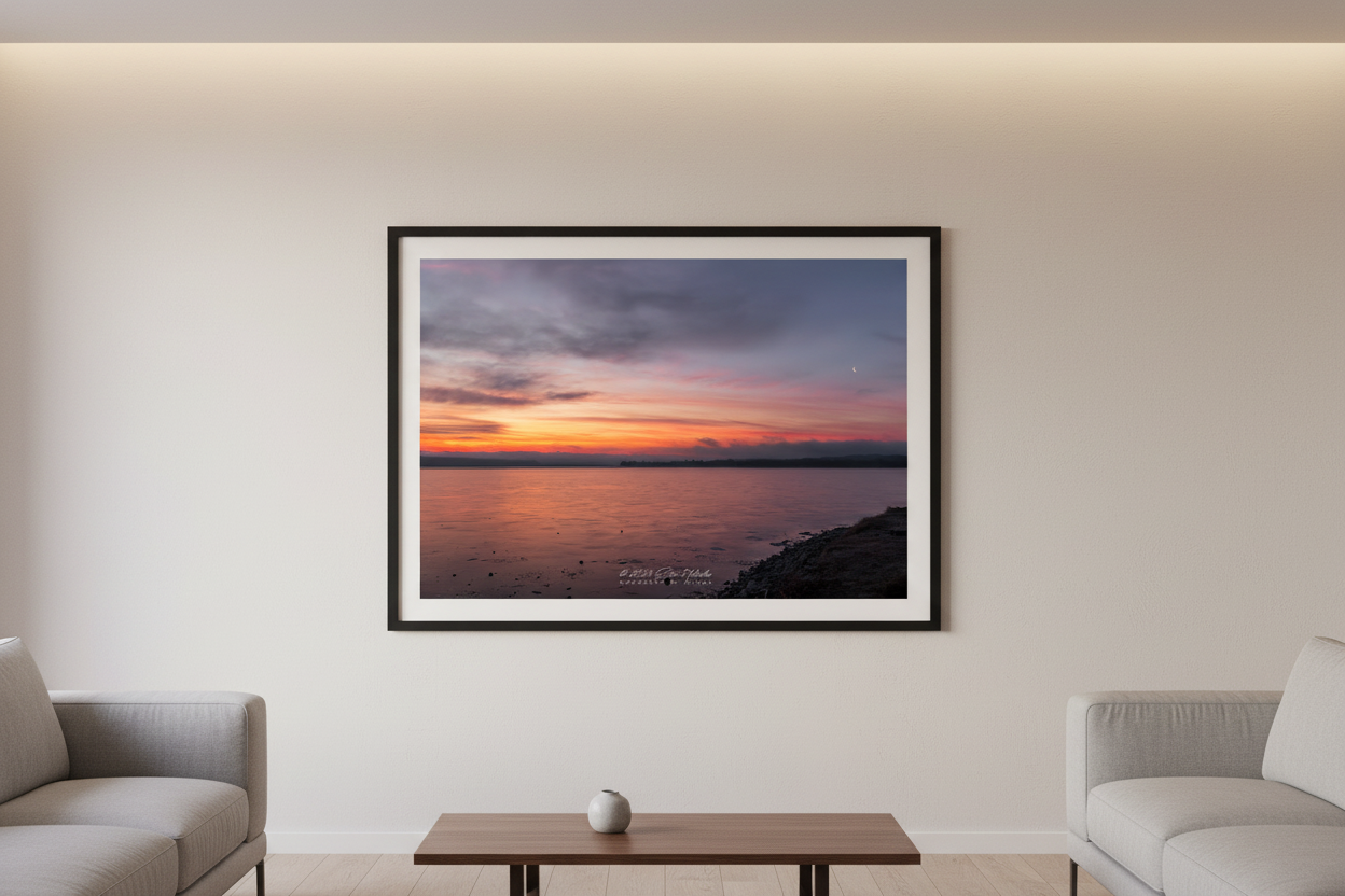 Large fine art landscape print of a fiery red sunrise with crescent moon over Lake Leelanau Michigan displayed in modern living room